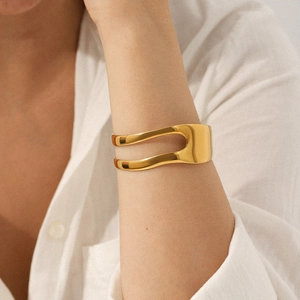Close-up of a 18K gold plated asymmetric open bangle showing the hollow design on a wrist