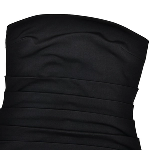 Dettaglio dell'abito a fascia nero con eleganti pieghe laterali e tessuto arricciato