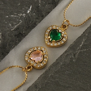 Detail of heart necklaces with green and pink gemstones and sparkling zircon borders
