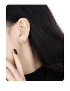 Detailed view of silver laurel leaf earrings and ring set with sparkling zircons