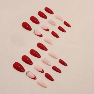 Glossy almond-shaped press-on nails in deep red and nude pink with rhinestones