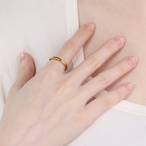 Close-up of a hand wearing a polished gold minimalist stainless steel stackable ring