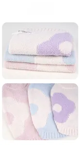 Close-up of thick knitted pet sweaters in pastel colors with floral patterns