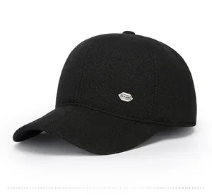 Detail view of winter baseball cap with ear flaps and metallic hexagon emblem in black