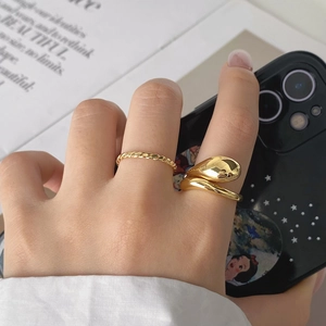 Detail of double-layered gold ring set with twisted band and streamlined water drop design