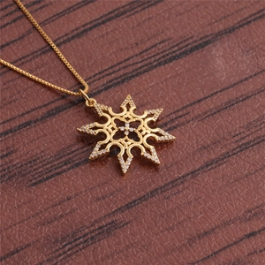 Detail of a vintage golden sunburst pendant necklace with hollow zircon inlay