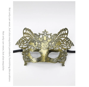 Gros plan du demi-masque vintage doré ajouré avec motifs papillon et oreilles de chat