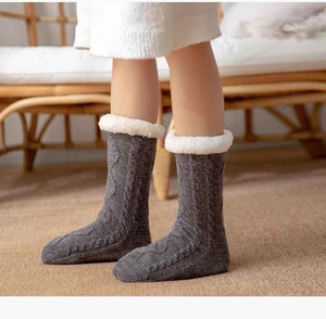 Detailed close-up of grey cable-knit winter floor socks with white plush cuffs for warmth