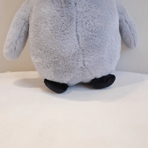 Close-up of soft grey plush penguin toy showing high-quality long hair texture