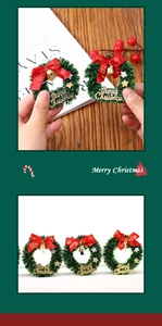 Close-up of miniature Christmas wreath with red bow, gold bell, and Merry Christmas sign