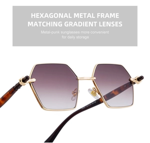 Detail of gold metal hexagonal sunglasses with purple gradient lenses and model engraving