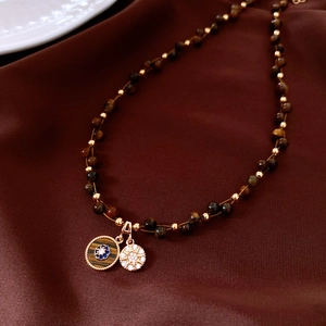 Détail macro d'un collier en œil de tigre avec pendentifs œil et étoile sur soie