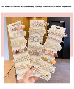 Close-up of handmade pearl and rhinestone hair clips set on white display cards