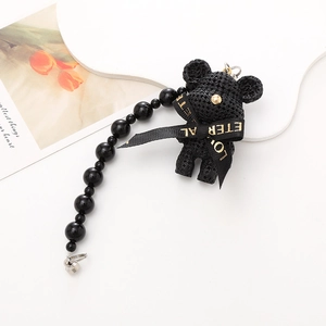 Handcrafted black knitted bear charm with golden lettering ribbon and beaded chain