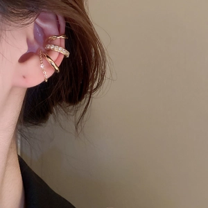 Detailed view of a gold-plated three-piece ear cuff set with rhinestones and drop chain