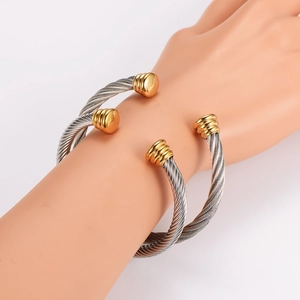 Detail of twisted cable cuff bracelet in two-tone silver and gold stainless steel