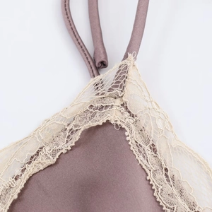 Detailed close-up of grey-purple satin fabric with delicate lace edges and spaghetti straps