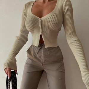 Close-up of the ribbed texture and buttons on this apricot deep V-neck knit cardigan