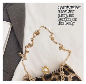 Detail of leopard print chain bag with golden strap and prominent pearl clasp decoration