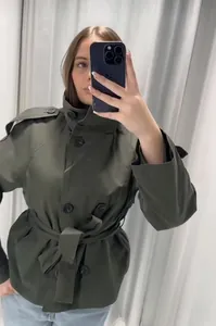Détail du trench-coat court croisé vert foncé avec ceinture et pattes d'épaules