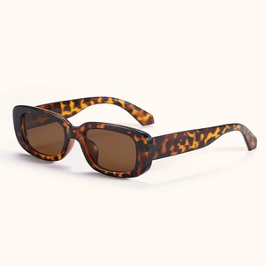 Detail view of stylish tortoiseshell rectangular sunglasses with dark brown lenses