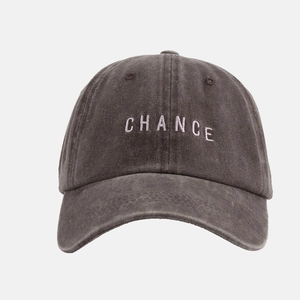 Detailaufnahme der weißen CHANCE-Stickerei auf einer gewaschenen dunkelgrauen Retro-Cap