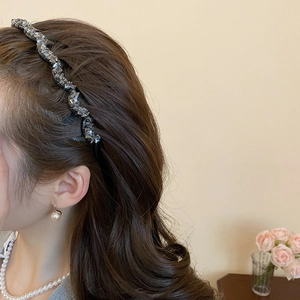 Detail of wavy crystal headband with grey rhinestones on model with pearl jewelry