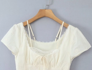 Close-up of white lace embroidery texture with ruffled edges and ribbon bow detailing