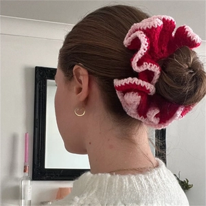 Detail of red and pink handmade crochet ruffle scrunchie worn on a hair bun