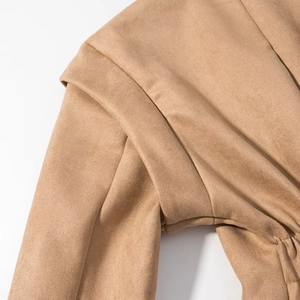Macro shot of khaki suede jacket shoulder showing high-quality stitching and fabric texture