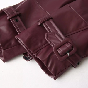 Detailed macro view of dark burgundy leather cuff with adjustable strap and buckle