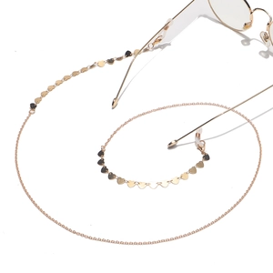 Chaîne à lunettes dorée avec breloques cœur et boucles antidérapantes sur fond blanc