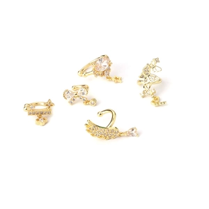 Elegant gold bow and feather ear cuff set with zircon stones on a white background