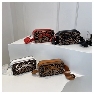 Detail view of colorful leopard print square bags with stylish bow accents and wide straps