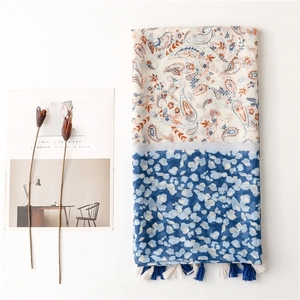 Bohemian paisley and leopard print shawl with tassels on a white minimalist background