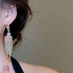 Macro shot of gold tassel earrings with cascading zirconia stones and sparkling fringe