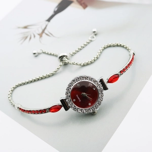 Detailed macro view of silver quartz watch with red gems and adjustable pull cord