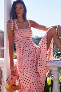 Detail of pink summer dress with red square print and stylish bow tie-up straps