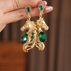 Nahaufnahme der Vintage Gold-Pferdekopf-Ohrringe mit grünen Edelsteinen und Kristallen