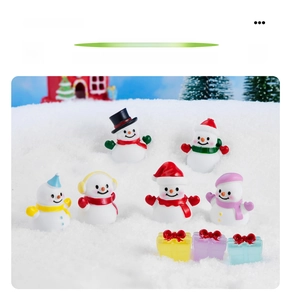 Vista macro dettagliata di figurine di pupazzo di neve in resina e regali in miniatura