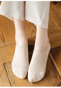 Close-up of beige breathable mesh no-show socks on model with natural wood background