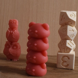 Detailed view of DIY handmade owl, bear, and dice-shaped candles on a wooden surface