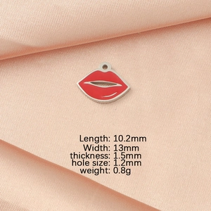 Red enamel lip pendant on silk fabric showing detailed dimensions and metal craftsmanship