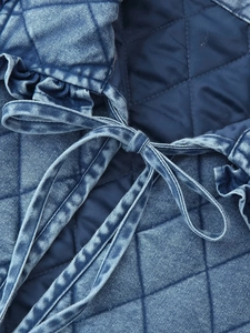 Close-up of diamond quilted washed denim fabric with decorative bow tie details