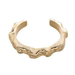 Minimalist gold-plated cuff bracelet featuring an irregular textured wave design and metal finish