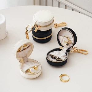 Close-up of portable round jewelry storage case with premium leather texture and zipper