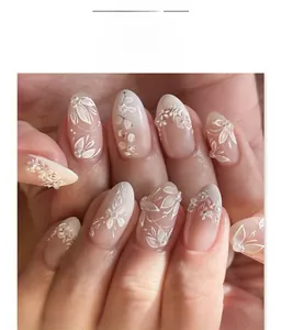Macro shot of almond-shaped nails with 3D white flowers, gradient pink base and pearl details