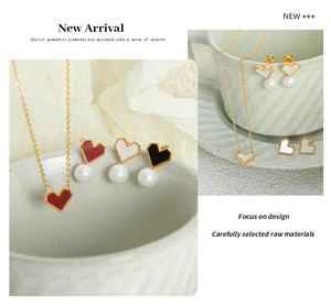 Close-up of heart-shaped jewelry set with enamel pendants and white pearl drops