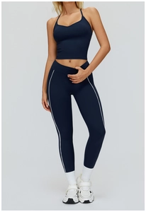 Détail de l'ensemble de yoga bleu marine avec leggings à bandes blanches et haut à col en V
