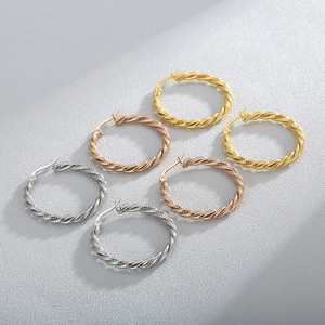 Detailed view of twisted rope design hoop earrings in gold, silver, and rose gold finishes